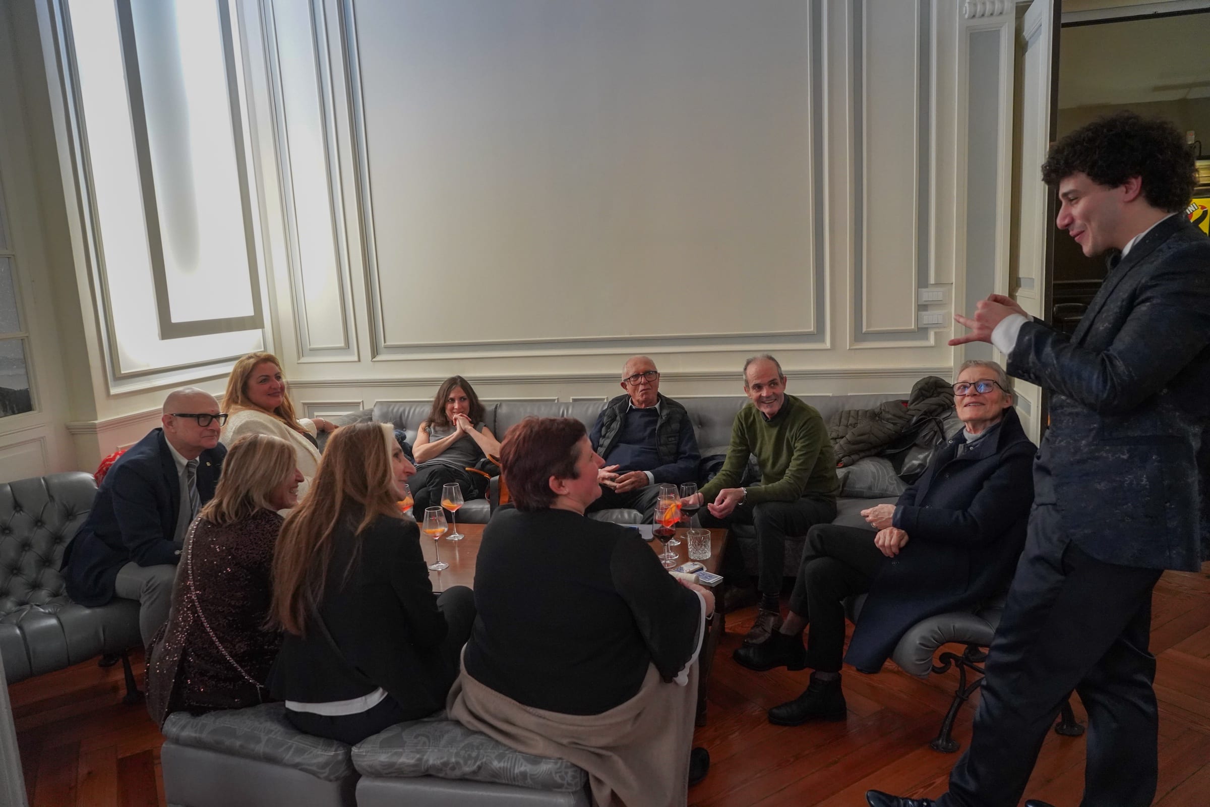 Matteo Angrisano davanti a un gruppo di ospiti seduti nei salotti di una dimora storica durante un evento aziendale